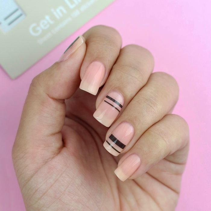 Get in Line thin black stripe decals on a sheer pink manicure with the packaging