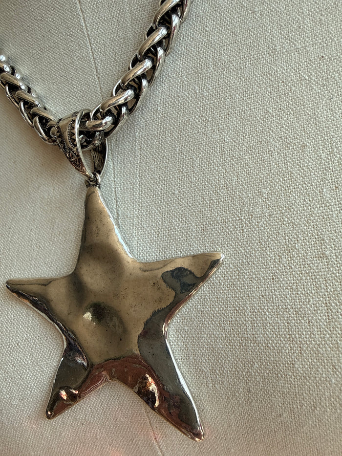 Silver-toned hammered star pendant with textured center on twisted chain link