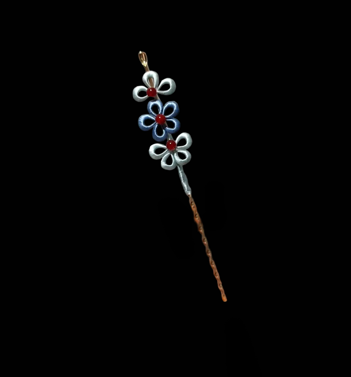 Close-up of delicate blue and silver layered flowers on handmade Chanhua hairpin