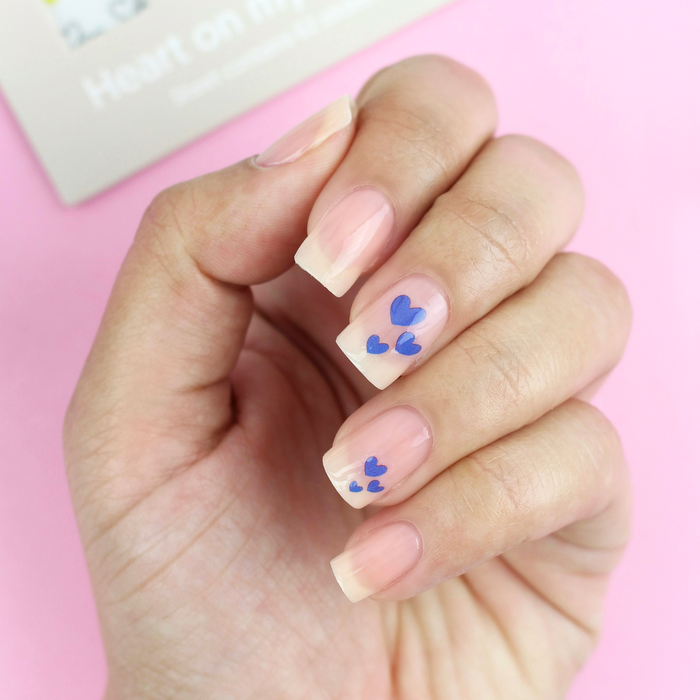 Heart on My Sleeve purple heart decals on a sheer nude manicure with the packaging