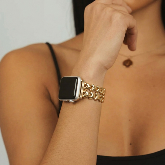 Gold Coconut Lane Hearts Chain Apple Watch strap on woman’s wrist, paired with necklace and black spaghetti strap top.