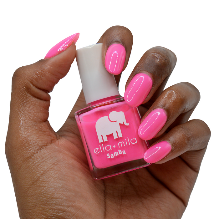 I Pink I Love You highlighter pink nail polish on a deep skin tone, hand holding the bottle