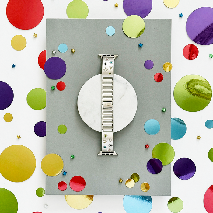 Ibiza Coloured Stone Apple Watch strap in Starlight on a gray-white background with scattered colorful confetti.