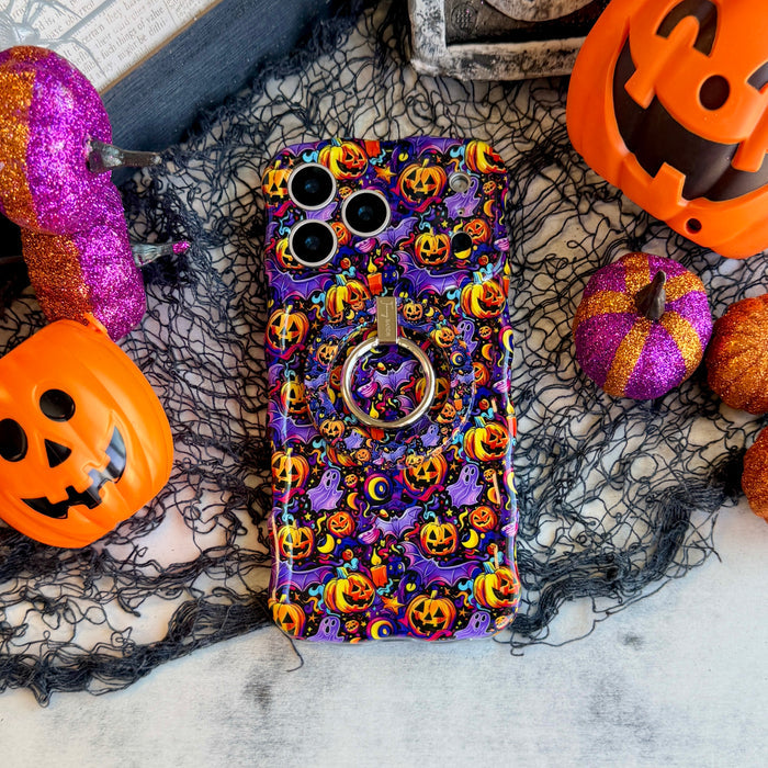 Jack-O-Lantern Jive Wavy Luxe MagSafe iPhone case with the matching MagSafe grip ring attached, styled with orange pails and magenta glitter pumpkins.