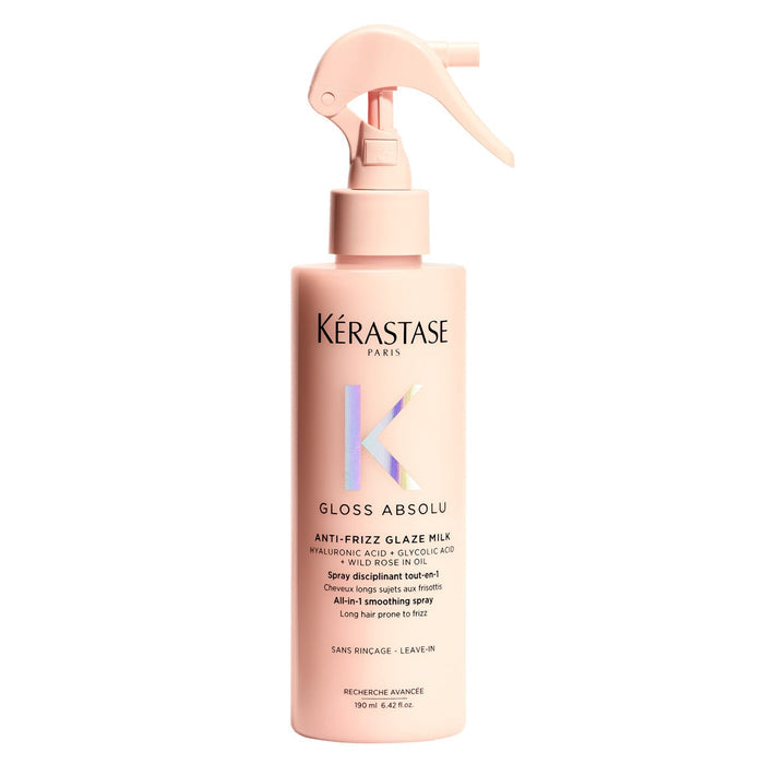 A bottle of Kerastase Gloss Absolu Anti-Frizz Glaze Milk with a spray pump, predominantly pink in color.