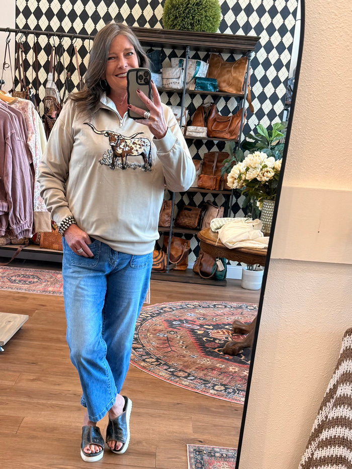 Model wearing a light taupe lightweight quarter-zip sweatshirt with longhorn embroidery