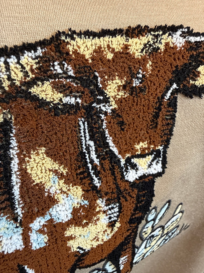 Close-up of longhorn embroidery on a light taupe lightweight quarter-zip sweatshirt