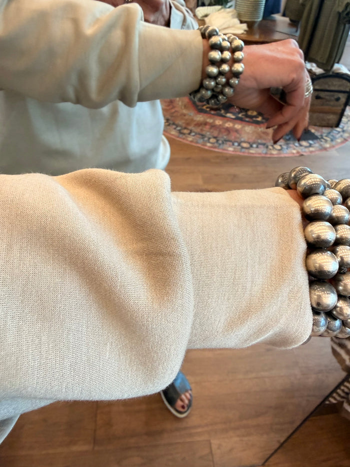 Back view of a light taupe lightweight quarter-zip sweatshirt sleeve and hem