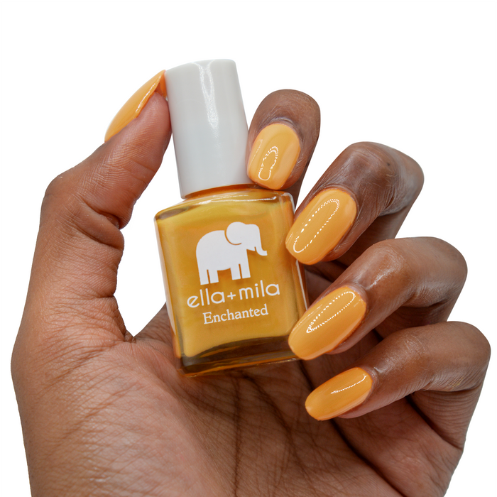 Lost City rustic mustard nail polish on a deep skin tone, hand holding the bottle