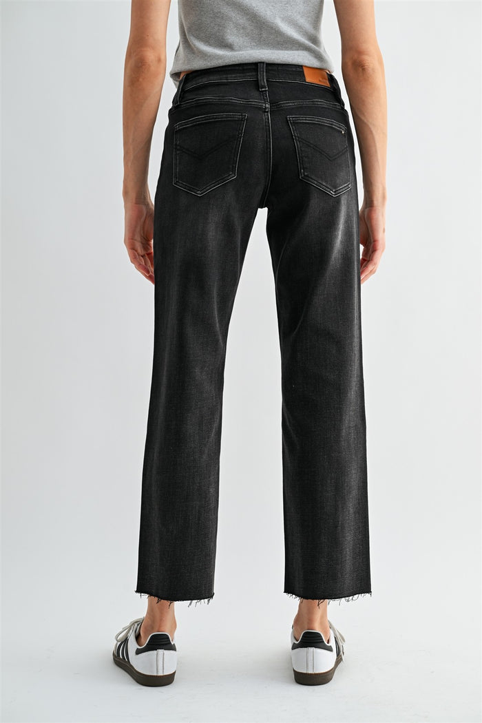 Mid-rise black straight ankle jeans, back view, stitched pockets and frayed hem