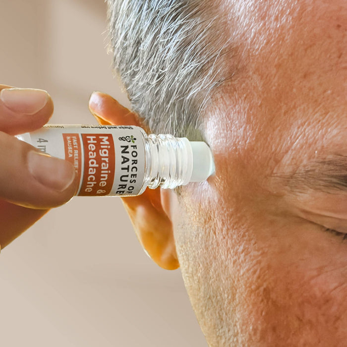 Person applying Migraine & Headache Relief roll-on to their temple