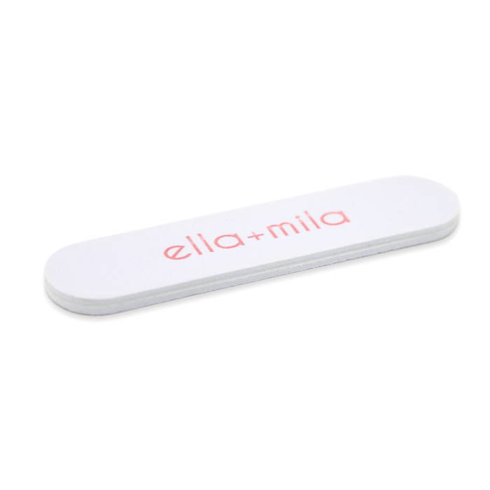 White mini half-moon nail file with ella+mila logo, angled view