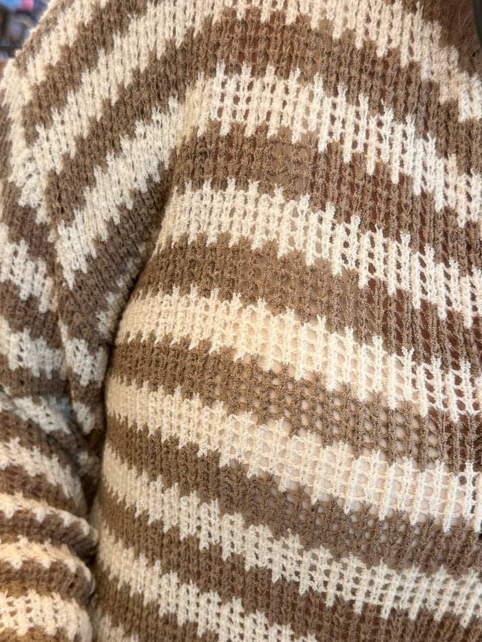 Close-up of mocha-and-cream striped knit sweater with raw, frayed edges