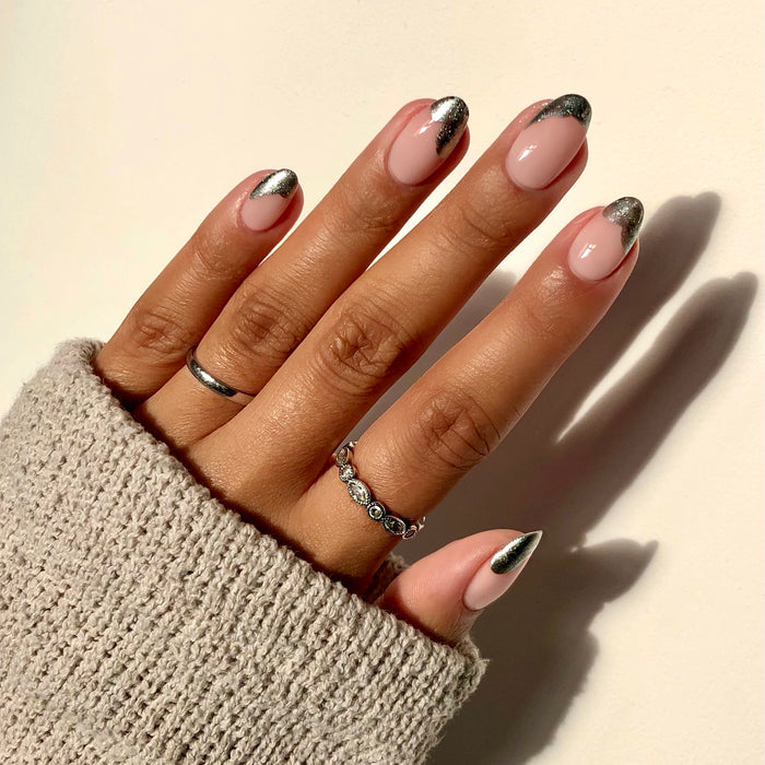 Moonshadow silver French tip nail art on a medium skin tone with rings