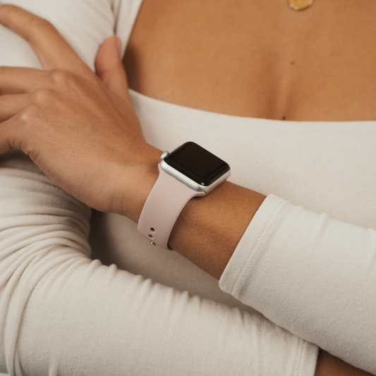 Person wearing a white long-sleeve shirt and a powder pink Coconut Lane NAKD Apple Watch strap.