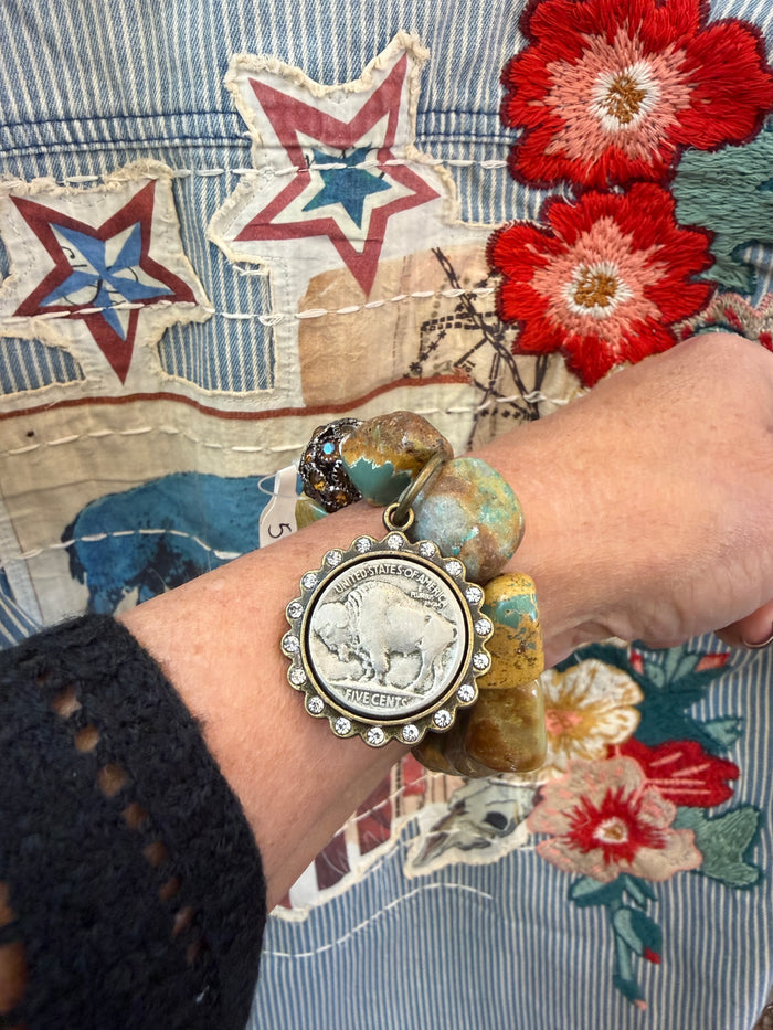 Natural turquoise stretch bracelet with round silver coin charm on wrist
