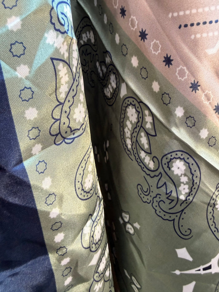 Wild rag scarf folded detail with navy, mint, and cream geometric paisley motifs