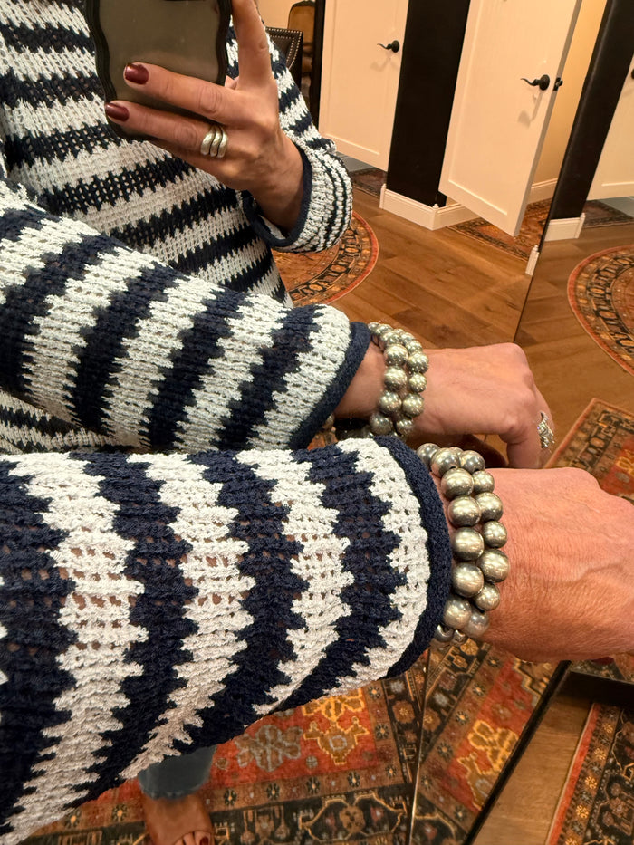 Striped loose knit sweater sleeve and cuff with raw-edged texture
