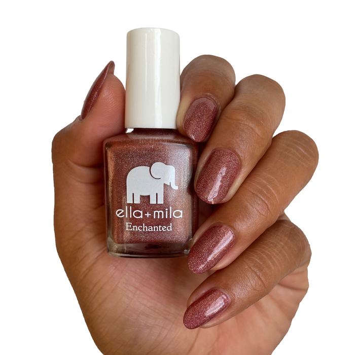 Oasis holographic red orange nail polish on a medium skin tone, hand holding the bottle