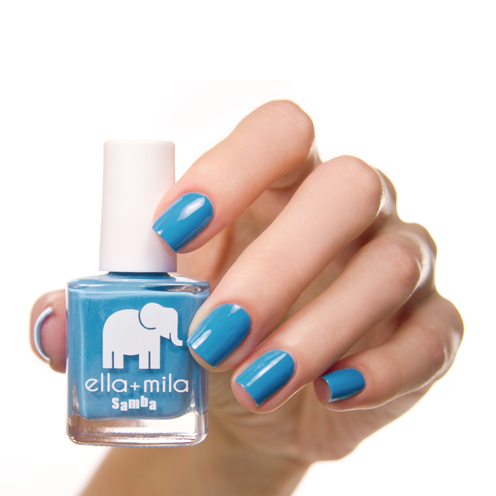 Ocean Air bright blue nail polish manicure on a light skin tone with the bottle