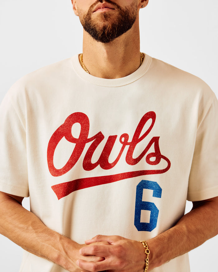 Cream t-shirt with red "Owls" script text and blue number 6 graphic on chest.