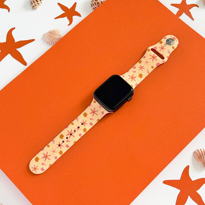 Peachy orange Apple Watch strap with starfish and shell pattern, featuring matching cutout details.
