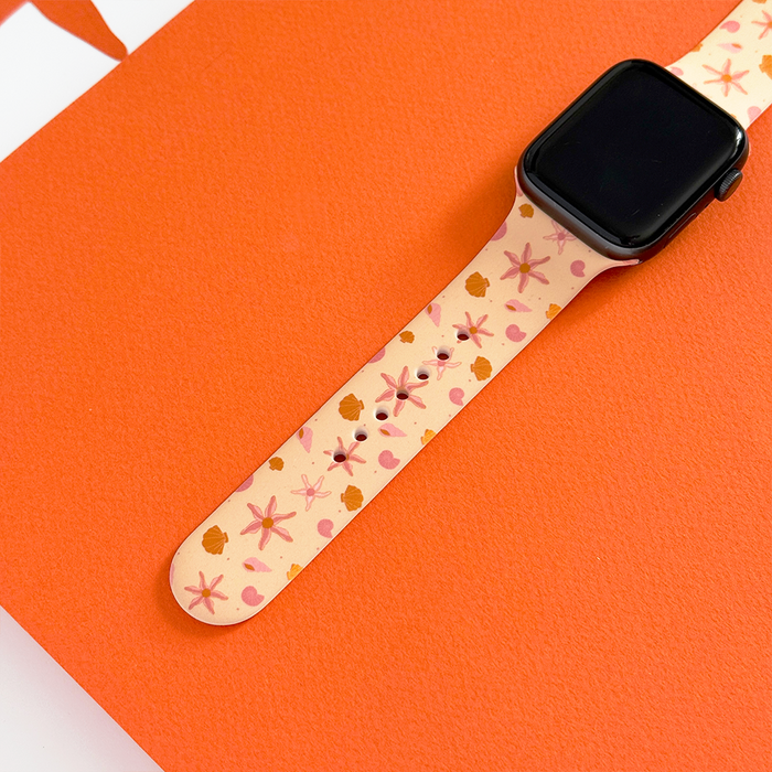 Peachy Beach Apple Watch strap by Coconut Lane on a vibrant orange textured background.