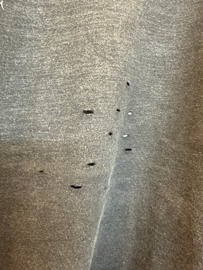 Heathered dark T-shirt fabric close-up with small specks and marks