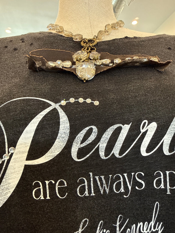 Dark T-shirt with pearl necklace graphic and script text 'Pearls are always ap'