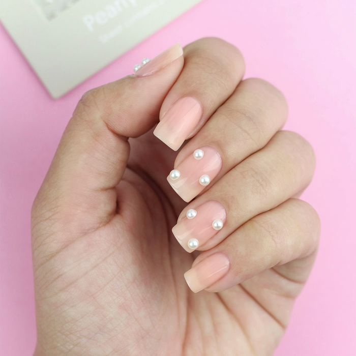Pearly Whites pearl decals on a sheer pink manicure with the packaging