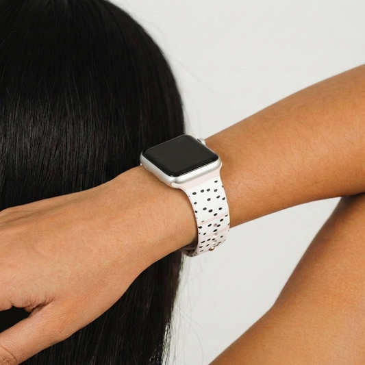 Pink Dalmatian-patterned Apple Watch strap from Coconut Lane worn on a wrist, set against a plain background.