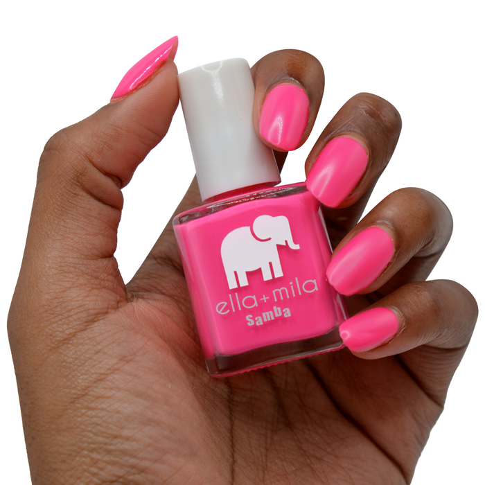 Pink Lemonade magenta nail polish on a deep skin tone, hand holding the bottle