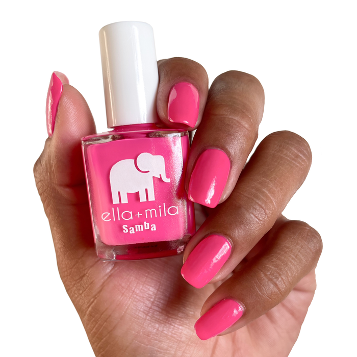 Pink Lemonade magenta nail polish on a deep skin tone, holding the bottle