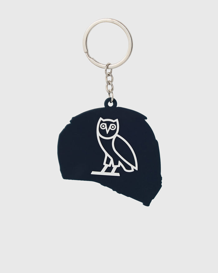 Black rubber helmet keychain with white owl logo and metal ring with chain attachment.