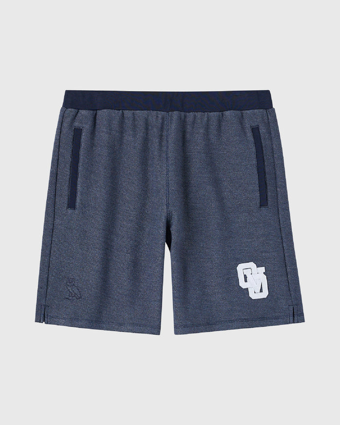 Royal navy reverse french terry sweatshort with elastic waistband, side zip pockets, and white logo patch on leg.