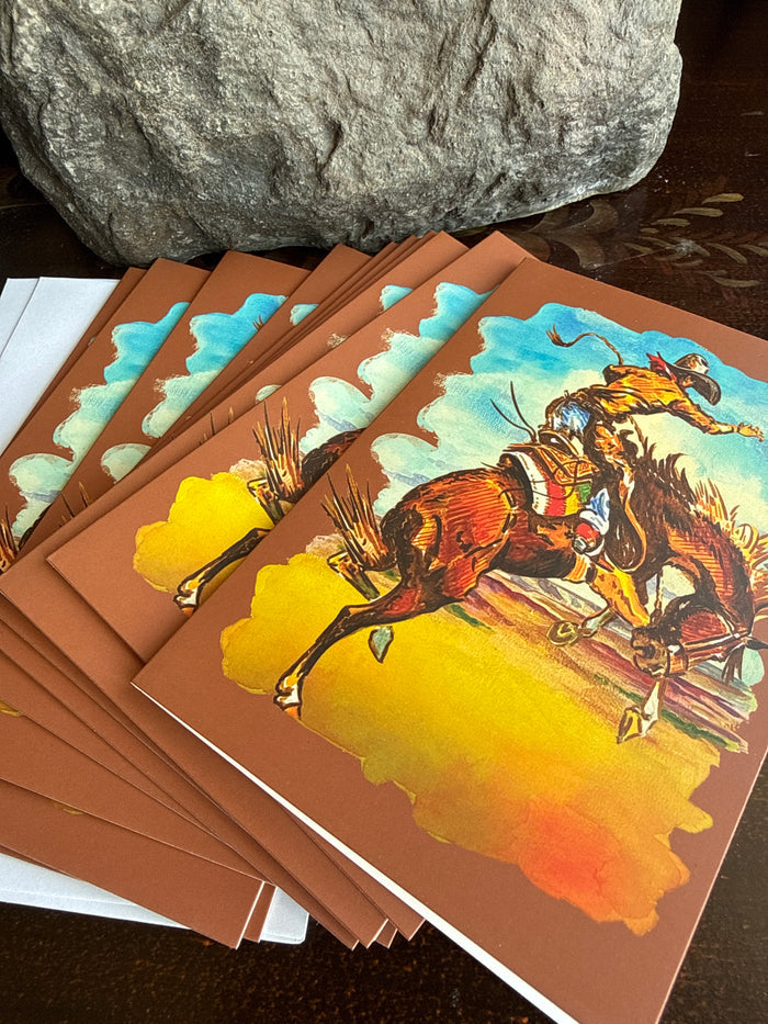 Set of saddle bronc note cards, stacked with teal-and-yellow western horse rider art