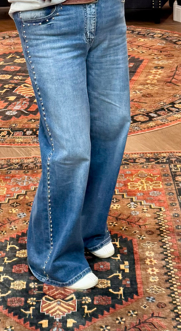 Light blue wide-leg denim jeans with stud trim on outer seam, classic five-pocket