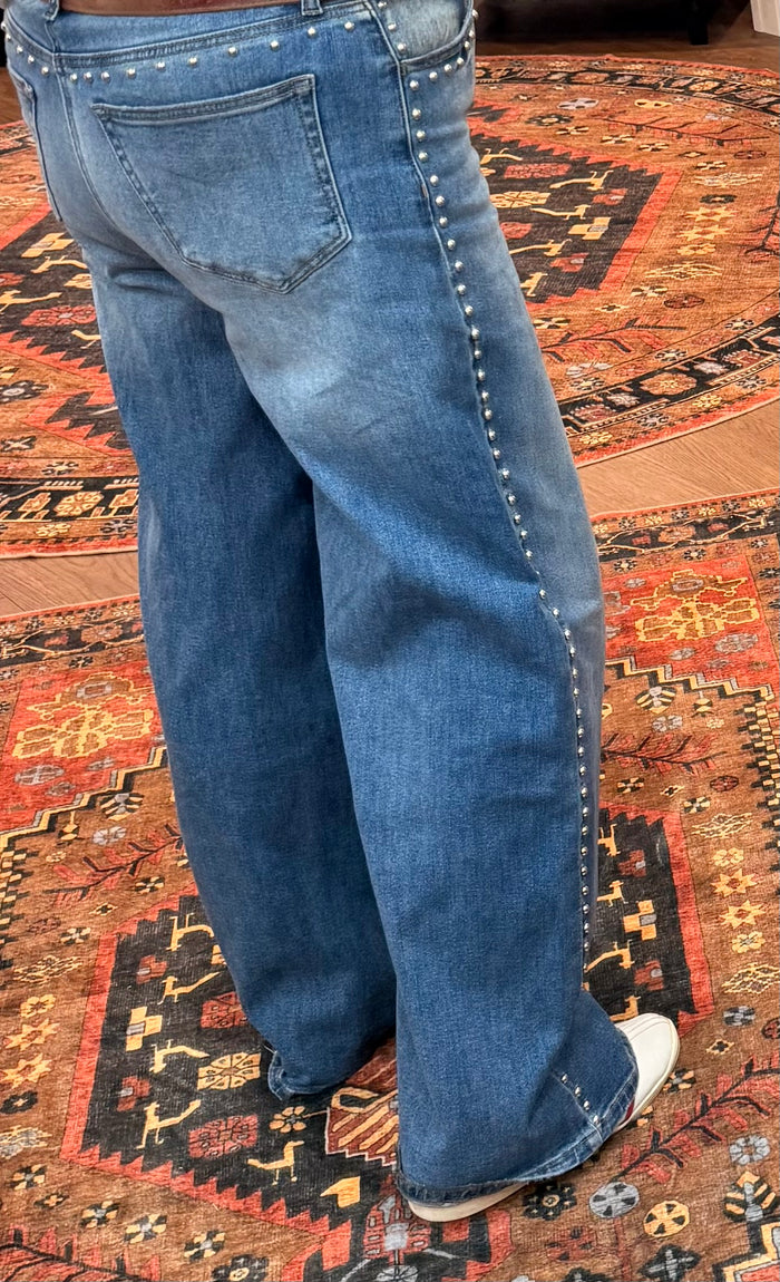Light blue wide-leg denim jeans with small studs along outer seam and hem