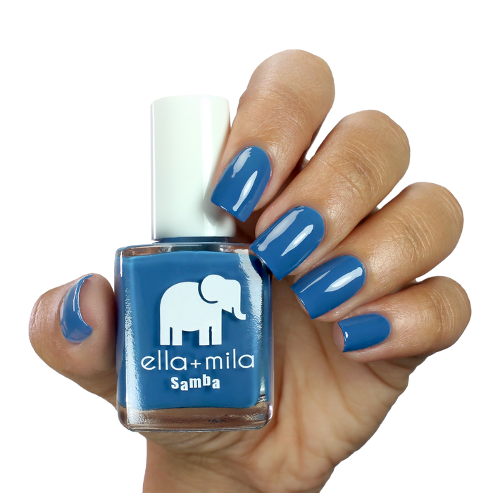 Summertime Sadness Egyptian blue nail polish on a medium skin tone, hand holding the bottle