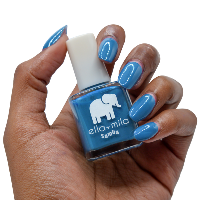 Summertime Sadness cobalt blue nail polish on a deep skin tone, hand holding the bottle