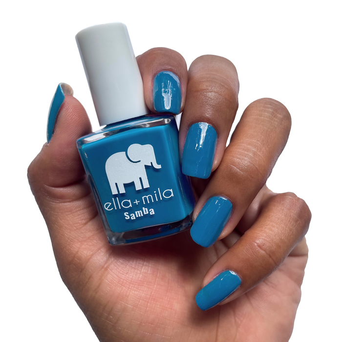 Summertime Sadness cobalt blue nail polish on a deep skin tone, holding the bottle