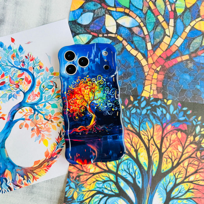 The Wishing Tree Wavy Luxe MagSafe iPhone case styled against stained-glass tree artwork in blue and autumn tones.