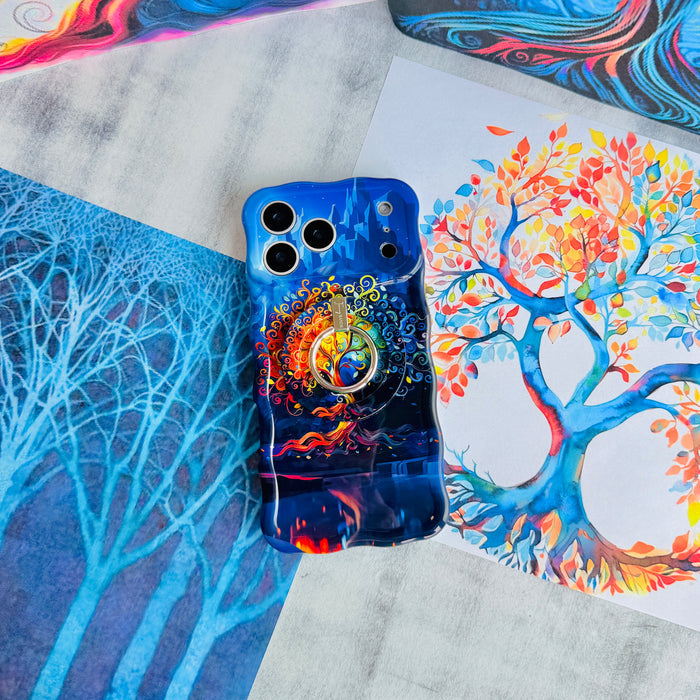 The Wishing Tree Wavy Luxe iPhone case with the matching MagSafe grip ring attached, styled on blue and orange tree illustration paper.