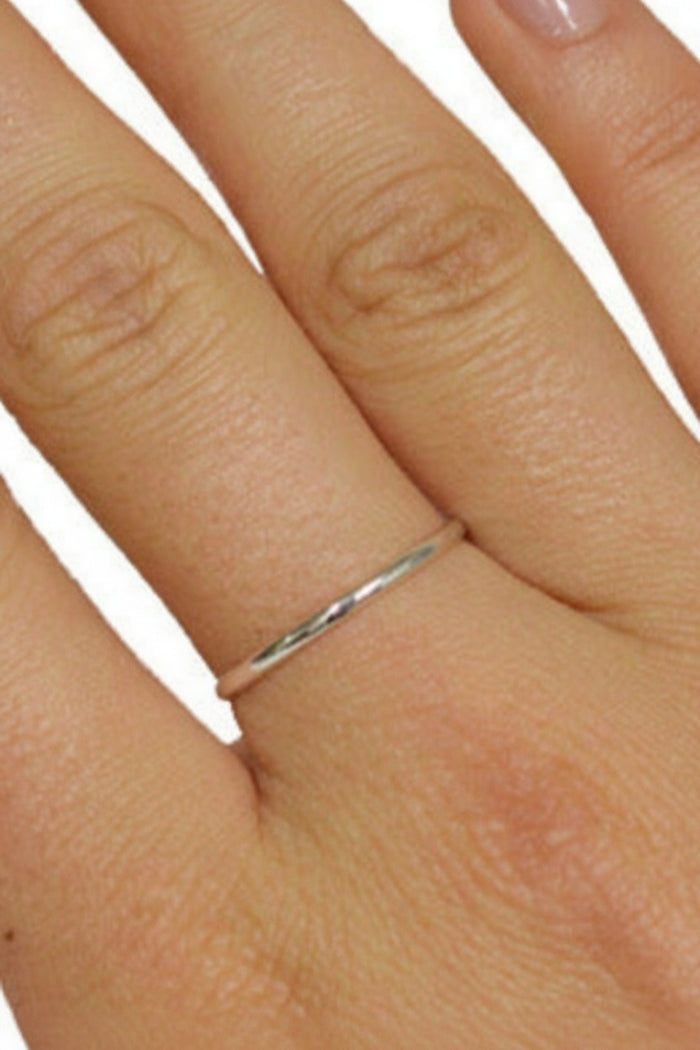 Thin sterling silver band ring worn on finger