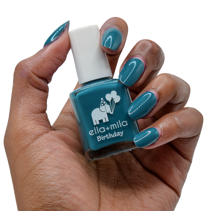 Third Time's a Charm sea blue nail polish on a deep skin tone, hand holding the bottle