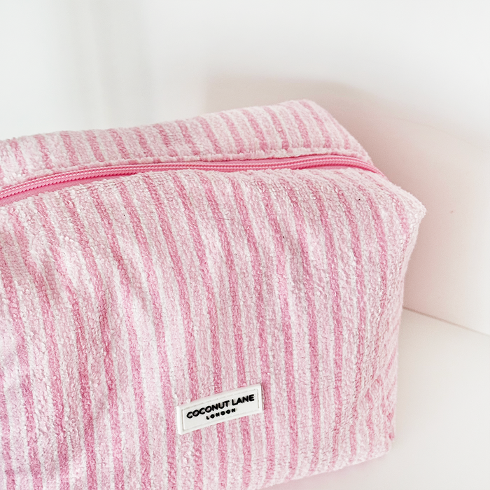 Towel makeup bag with powder pink and white stripes, soft textured fabric, Coconut Lane logo on the front.