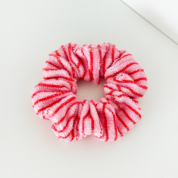 Pink and red striped towel scrunchie with a soft, absorbent texture.