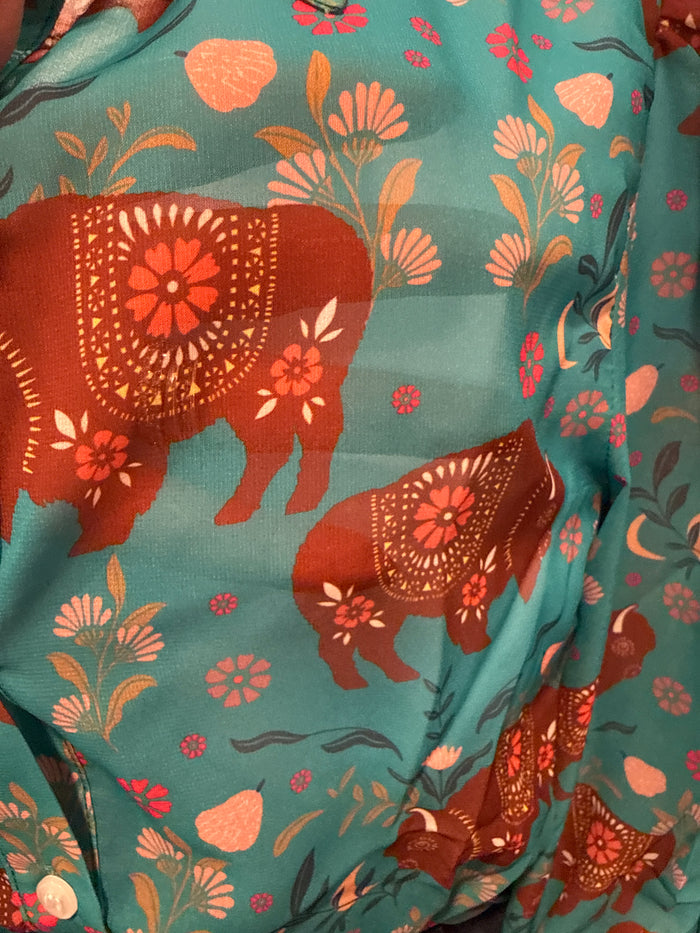 Turquoise semi-sheer blouse close-up: brown elephant print with orange flowers