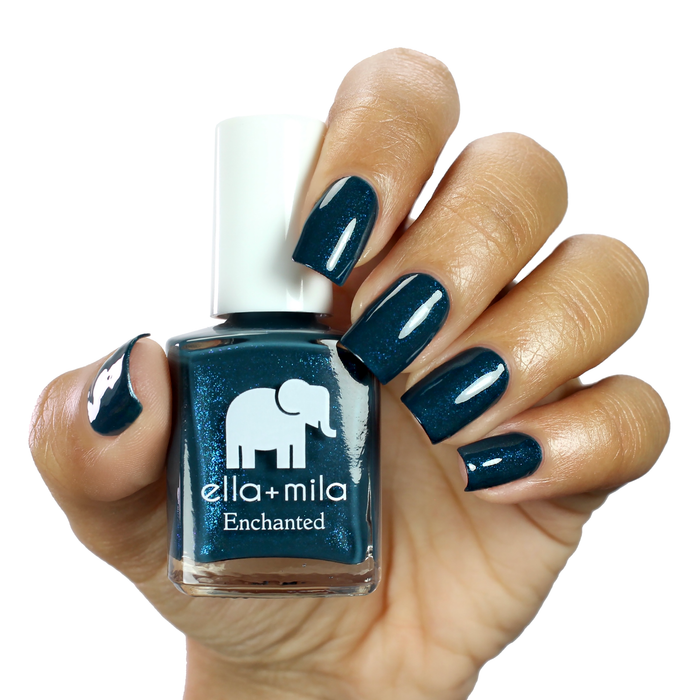 Twilight royal blue shimmer nail polish on a medium skin tone, hand holding the bottle