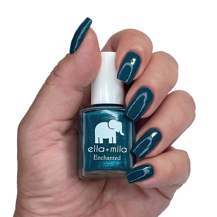 Twilight muted blue shimmer nail polish manicure on a light skin tone with the bottle